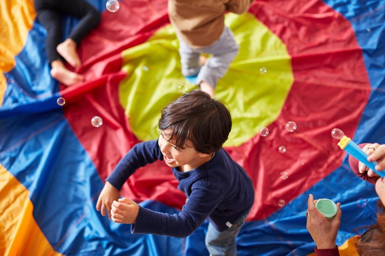 Child participating in a colorful parachute activity