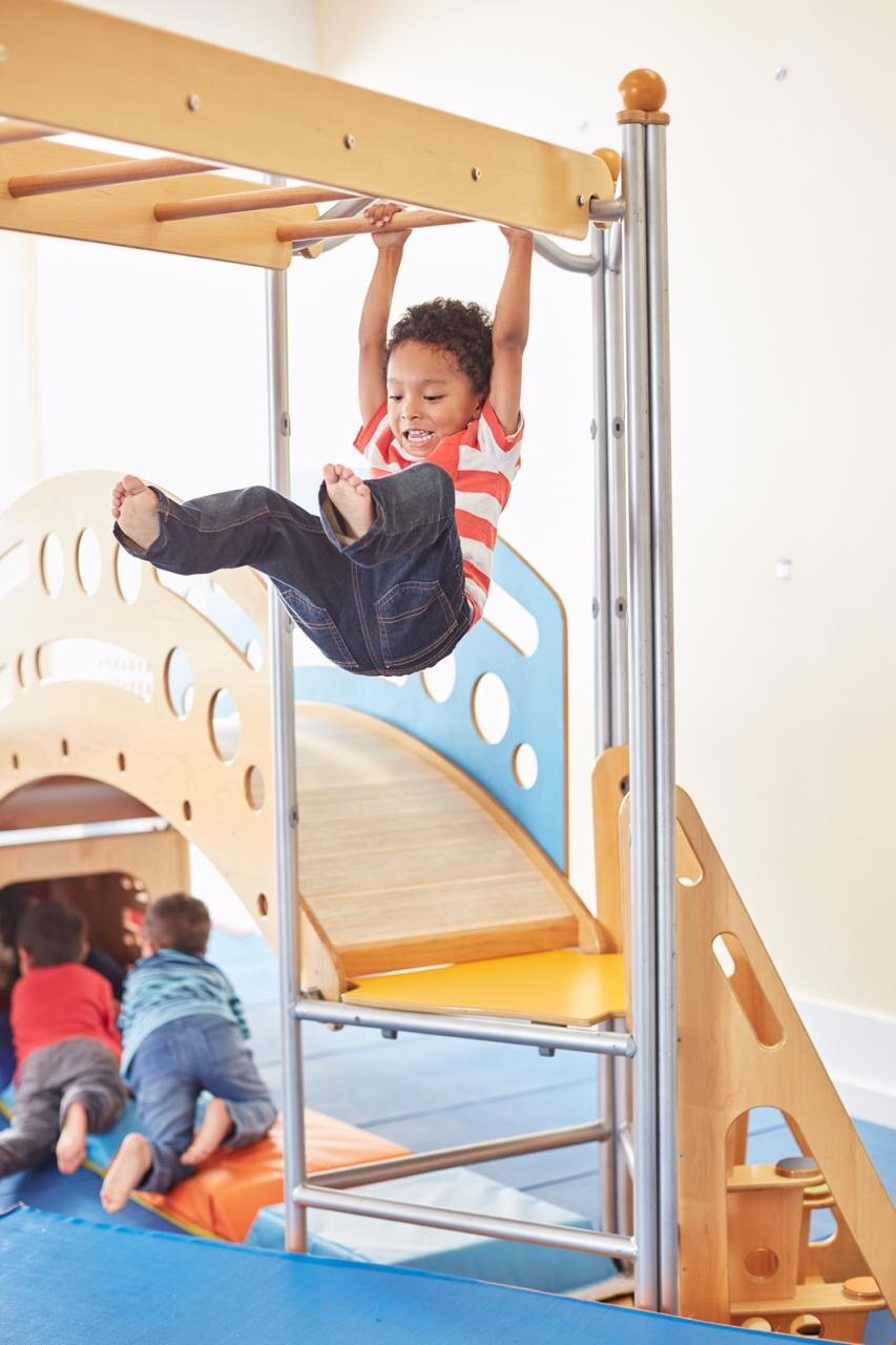 Child exploring the indoor play structure at Gymboree