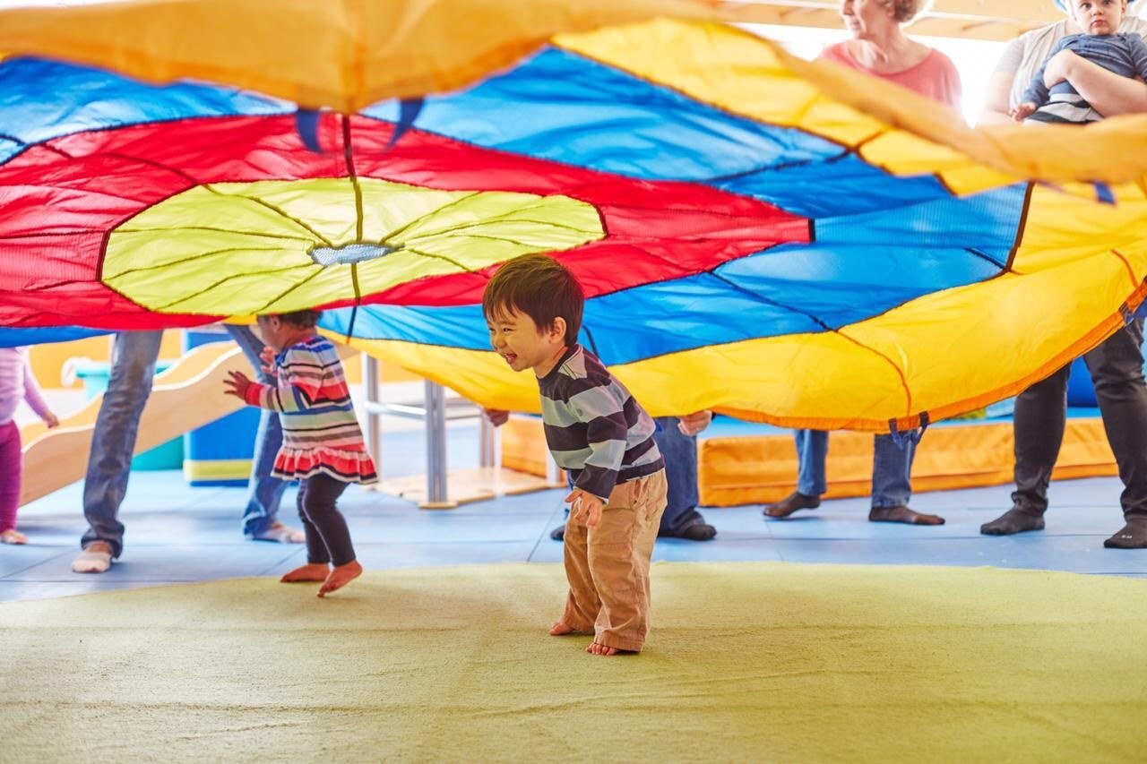 Parents and children enjoying a Gymboree group activity